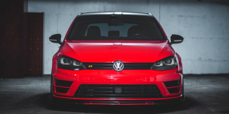 Entrance to a luxury underground garage with red car parked on sloped entry ramp